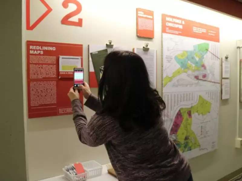 Individual taking picture of the Undesign the Redline exhibit