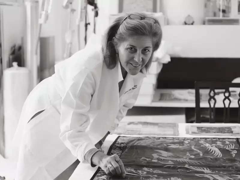 Julia Brennan leaning over a textile
