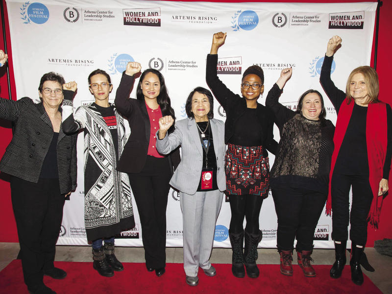 Several women raise a fist at the Athena Film Festival