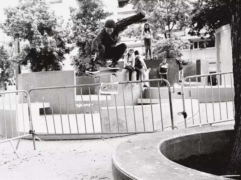 Alexis Sablone ’08 on a skateboard, flying over a fence in Paris