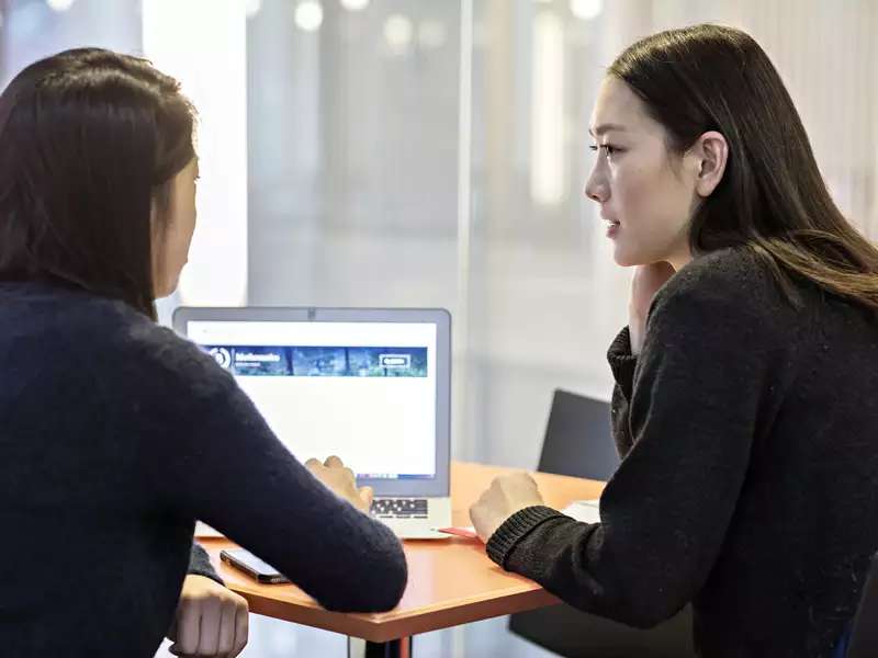 2 women students working together on a laptop