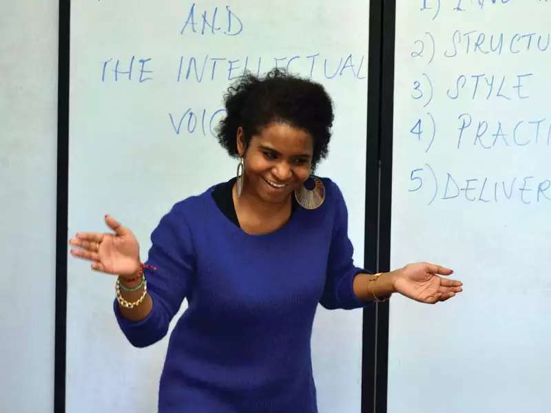 A Black woman who's a speaking fellow looks happy with her presentation