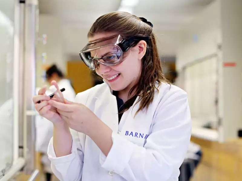 Student in a lab coat holding a test tube