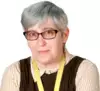 photo of a middle aged white woman with short bluish hear, wearing glasses and a bit of a smirk